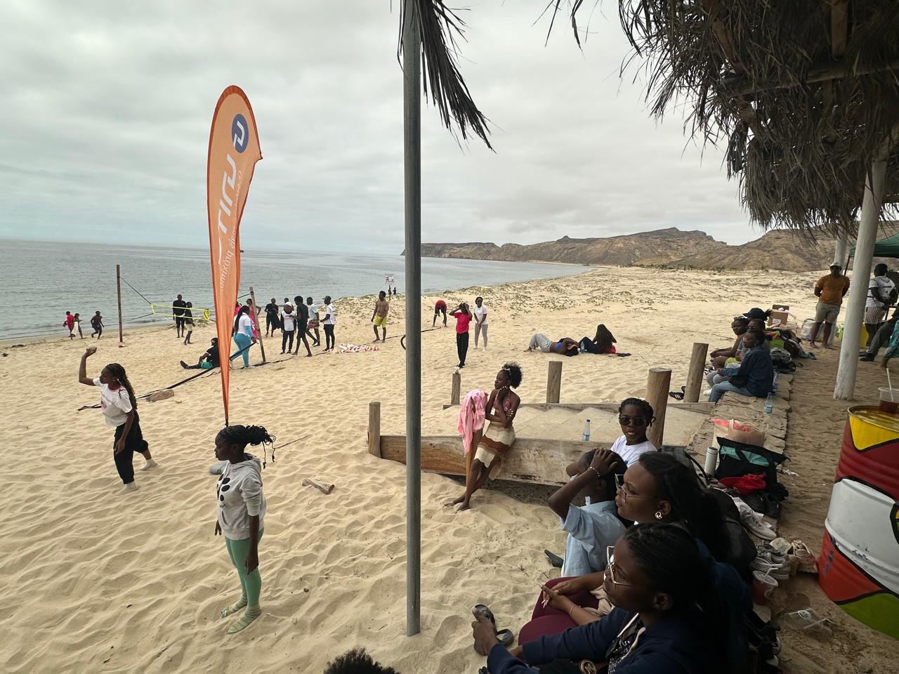 Young people on the beach beside a UNITEL flag during the Festival
